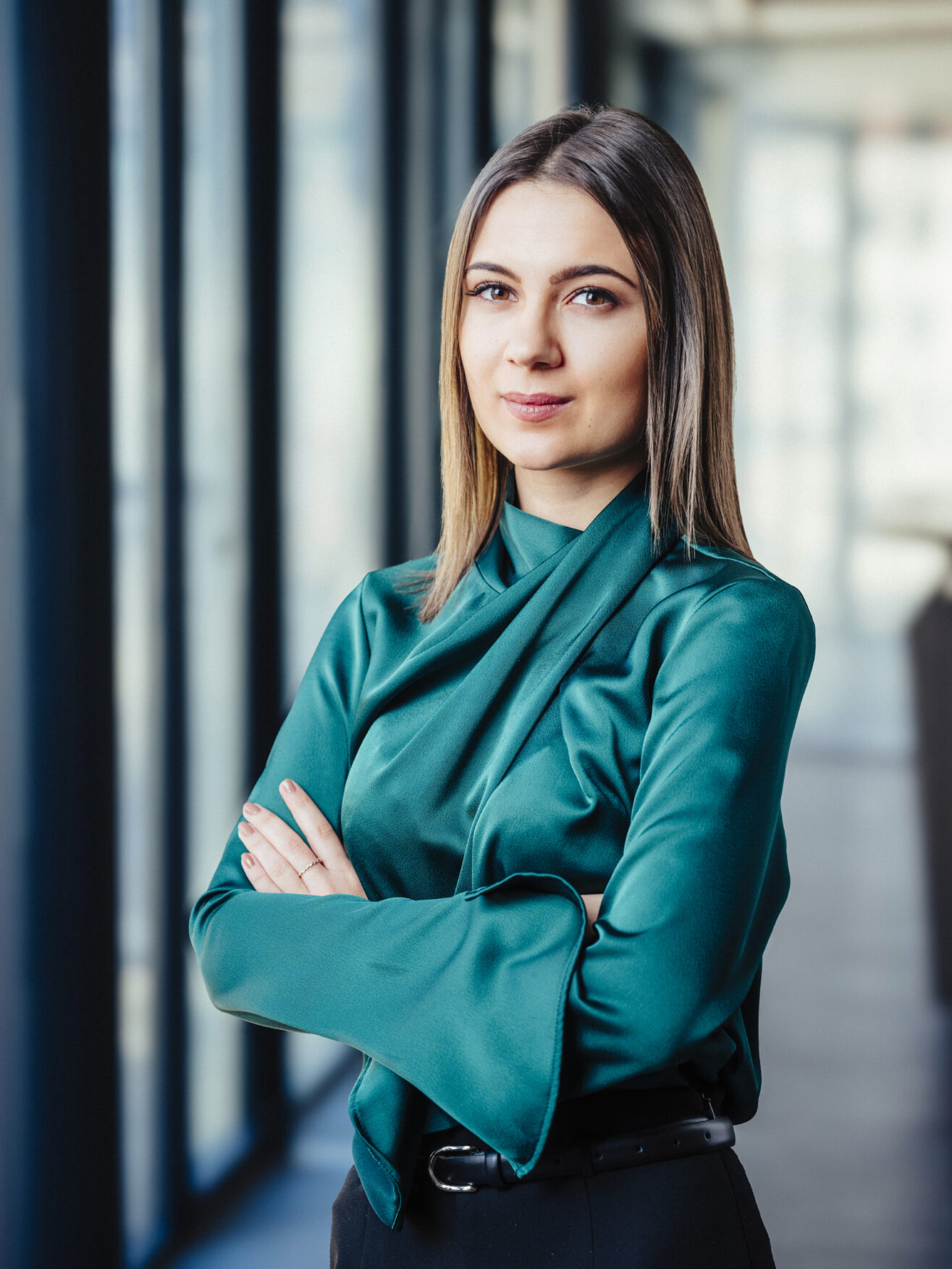 Porträt von Valentina Planchenstainer, PrivateBanking-Expertin der Hypo Tirol, mit verschränkten Armen vor einer Fensterfront