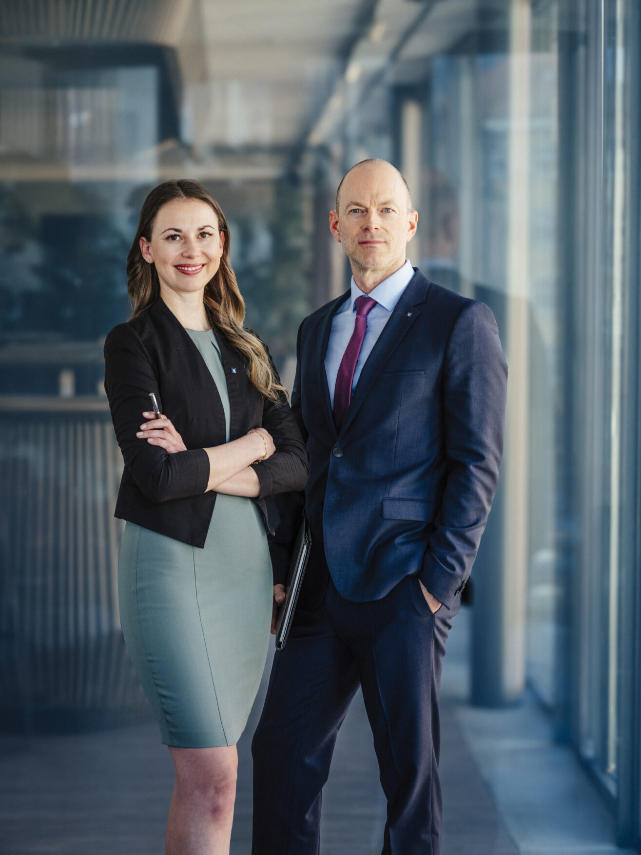 Yvonne Unterkircher und René Schneider stehen gemeinsam im Büro mit Unterlagen für die Beratung